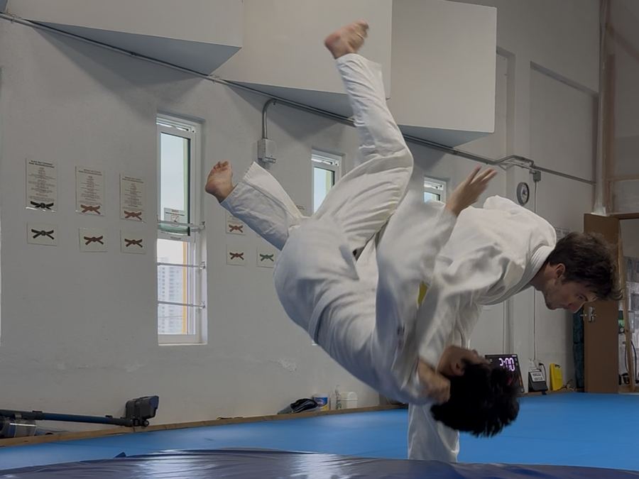 Completing a judo throw, training partner airborne above the mat