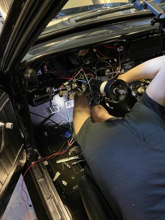 Rewiring the dashboard of a classic car, wiring harness pulled out from under the dash